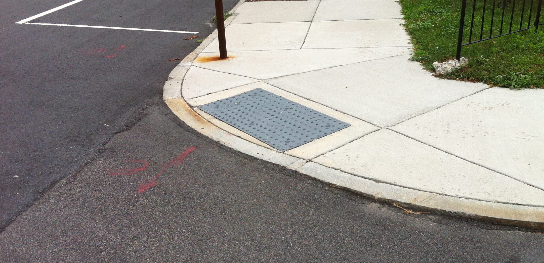a generic looking curb cut. it's a wedge cut into the sidewalk to allow wheelshairs to move between the sidewalk and street at an intersection